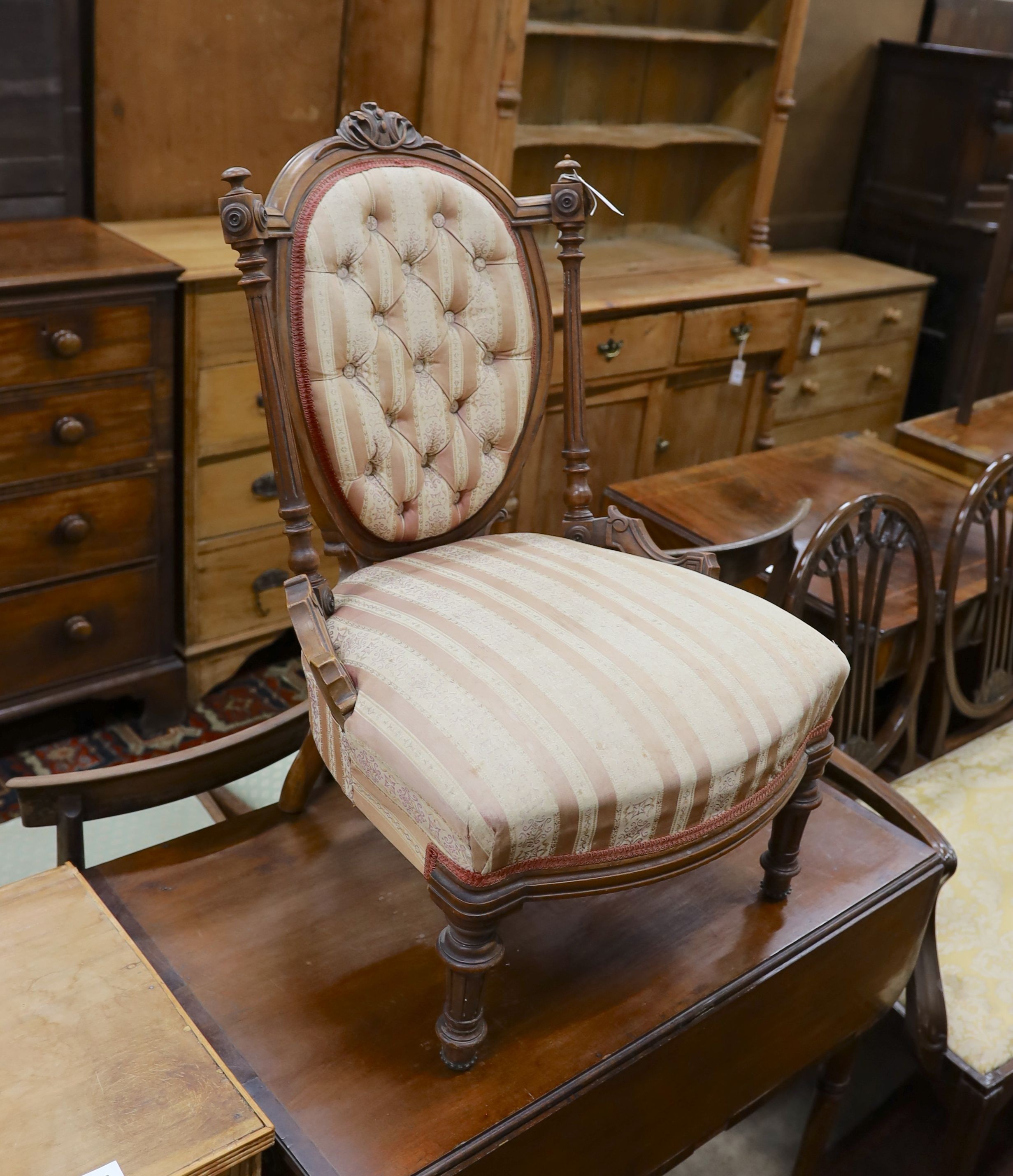 A small late Victorian carved walnut sewing chair, with buttoned back and turned legs, width 53cm, depth 50cm, height 80cm